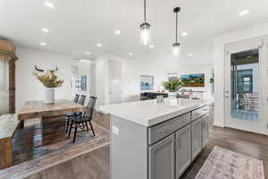 Kitchen featuring recessed lighting, a kitchen island, light countertops, gray cabinets, and dark wood-style floors