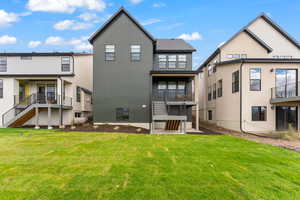 Rear view of house featuring stairway and a yard