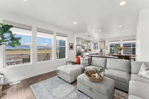 Living room featuring baseboards, dark wood finished floors, visible vents, and recessed lighting