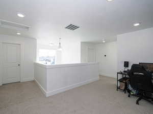 Office with light carpet, visible vents, baseboards, and a textured ceiling