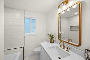 Bathroom featuring toilet, baseboards, and vanity