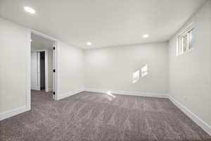 Carpeted empty room with recessed lighting and baseboards