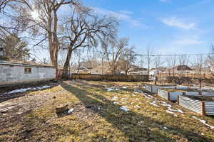 View of yard featuring a vegetable garden and fence