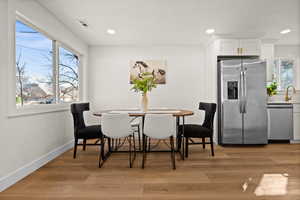 Dining area featuring light wood-style flooring, recessed lighting, visible vents, and baseboards