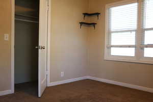 Unfurnished bedroom with carpet floors and baseboards