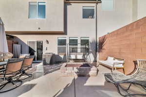 Back of house with fence, visible vents, stucco siding, outdoor dining space, and a patio area