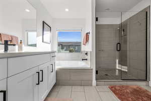 Full bathroom with a bath, a shower stall, a wealth of natural light, and vanity