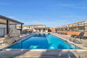 Community pool featuring a residential view, a patio area, and fence