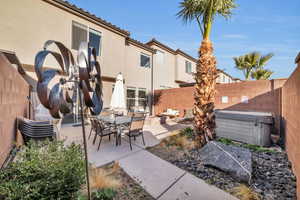 View of patio with a hot tub, a fenced backyard, and outdoor dining space