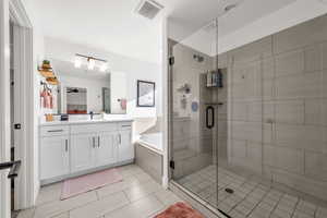 Full bath with a garden tub, vanity, visible vents, a ceiling fan, and a shower stall