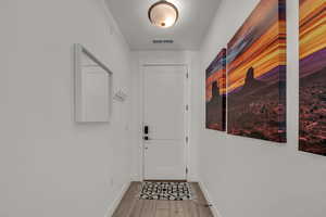 Entryway with visible vents, light wood-style flooring, and baseboards