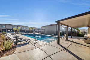 Pool with a patio area and fence