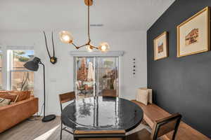 Dining area featuring visible vents, a notable chandelier, and wood finished floors