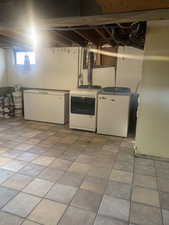 Below grade area featuring separate washer and dryer and fridge