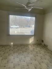 Unfurnished room with brick floor, a healthy amount of sunlight, ceiling fan, and visible vents