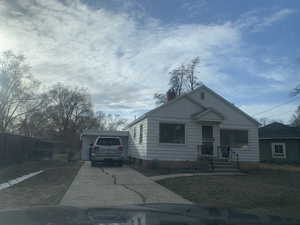 Bungalow-style house featuring driveway, a chimney, and fence