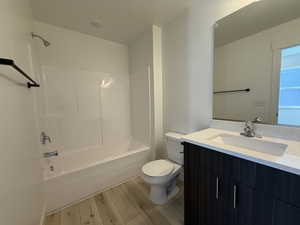 Full bath featuring vanity, shower / tub combination, wood finished floors, and toilet