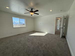 Carpeted empty room with a textured ceiling, ceiling fan, recessed lighting, visible vents, and baseboards