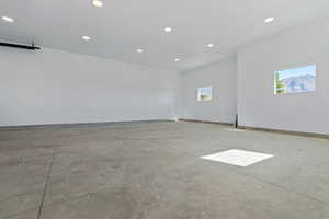 Empty room featuring concrete flooring, plenty of natural light, baseboards, and recessed lighting