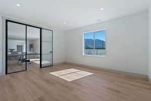 Unfurnished room featuring visible vents, light wood-style flooring, and baseboards