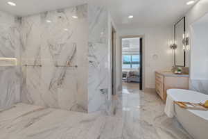 Full bath with ensuite bathroom, recessed lighting, vanity, marble finish floor, and a soaking tub