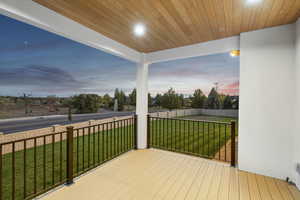 Deck at dusk with a yard and fence