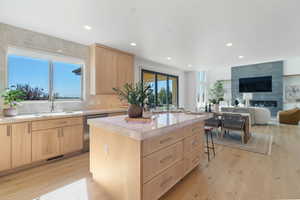 Kitchen featuring a sink, light wood finished floors, light brown cabinets, and dishwasher