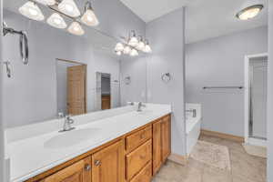 Bathroom with a shower stall, a sink, and tile patterned floors