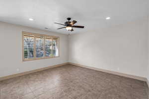 Empty room featuring ceiling fan, a textured ceiling, and baseboards