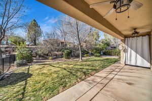 View of yard featuring a patio, fence, and a ceiling fan