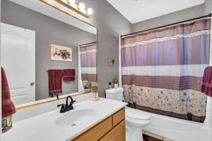 Bathroom featuring shower / tub combo, tile patterned flooring, vanity, and toilet