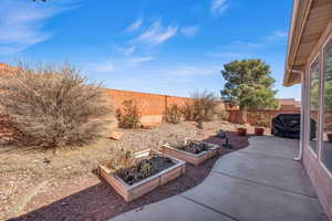 View of patio featuring a fenced backyard and a vegetable garden