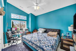 Carpeted bedroom with lofted ceiling, baseboards, visible vents, and a ceiling fan