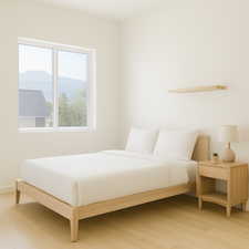Bedroom with light wood-type flooring and a mountain view with virtual staging