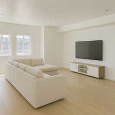 Living area featuring light wood finished floors and baseboards with virtual staging