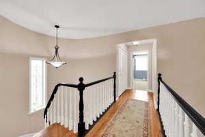 Upstairs landing with hardwood floors, open to foyer