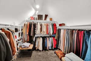 Walk in closet with vaulted ceilings in primary bedroom