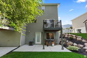 Rear view of house featuring a patio, a balcony, cooling unit, a mountain view, and stucco siding