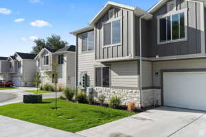 View of home's exterior with board and batten siding, a residential view, stone siding, and driveway