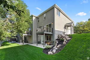 Back of house with a yard, cooling unit, a patio, and stucco siding