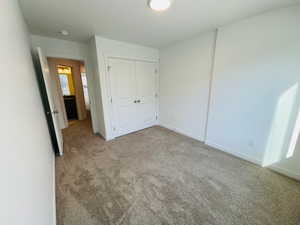 Unfurnished bedroom with a closet, carpet flooring, and baseboards