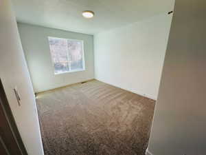 Carpeted spare room with baseboards