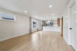 Unfurnished living room with baseboards, light wood finished floors, and recessed lighting