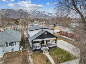 View of front of home featuring covered porch, a shingled roof, a residential view, and a mountain view