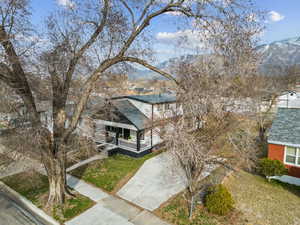 View of front of house featuring a mountain view, a porch, concrete driveway, and brick siding