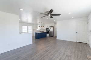 Open concept living room featuring  wood-style floors, baseboards, and a ceiling fan