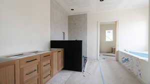 Full bath with a textured ceiling, a tub to relax in, and a tile shower