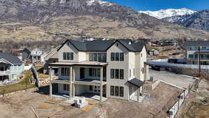 Back of property featuring a residential view, a mountain view, and a patio