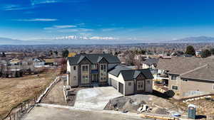 View of front of house with driveway, a residential view, a mountain view, and stucco siding