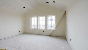Interior space with lofted ceiling, a textured ceiling, and baseboards